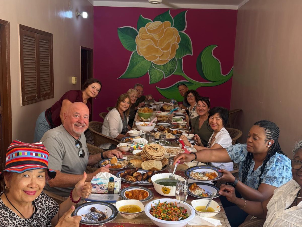 Travelers sharing a home-cooked meal around one table