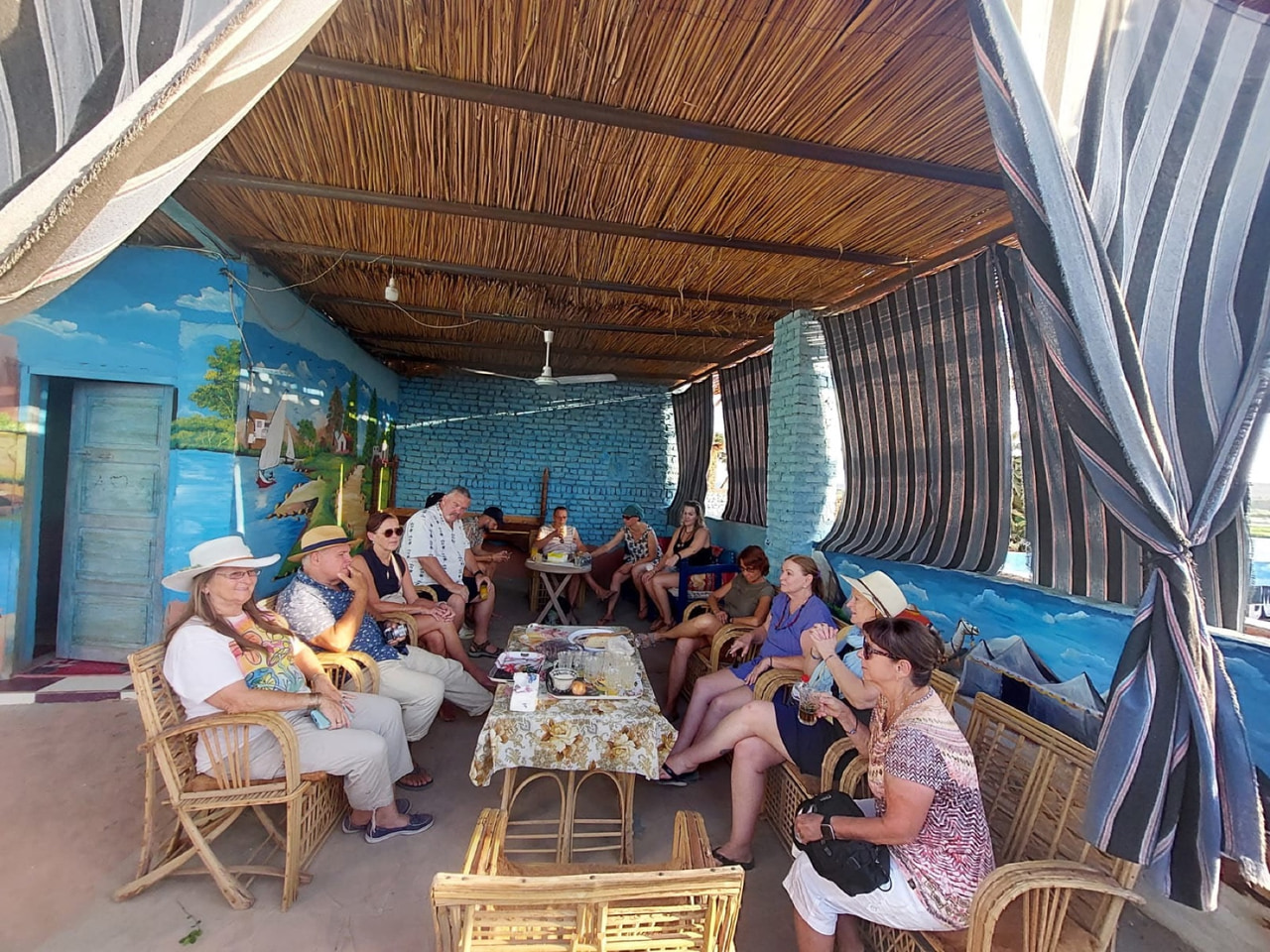 The group sitting together inside a brightly painted Nubian house