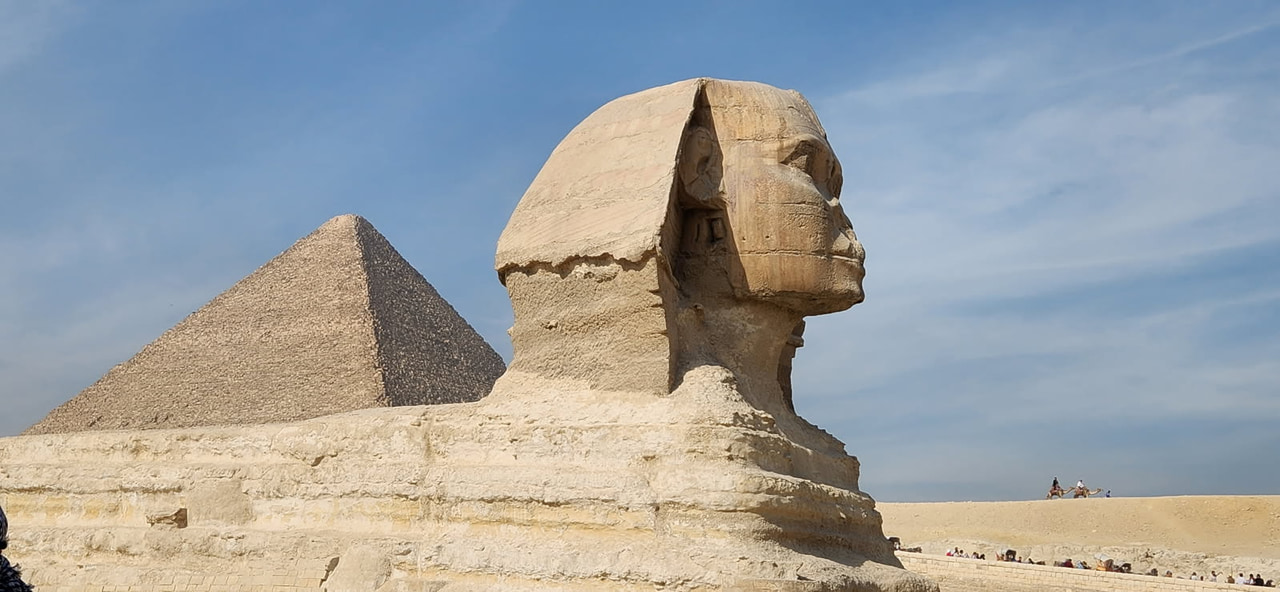 The Great Sphinx of Giza with a pyramid rising behind it